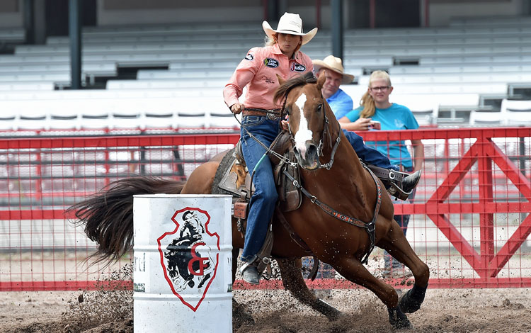 Barrel Racer Shali Lord and her horse turning a barrel at the Cheyenne Frontier Days Rodeo. 